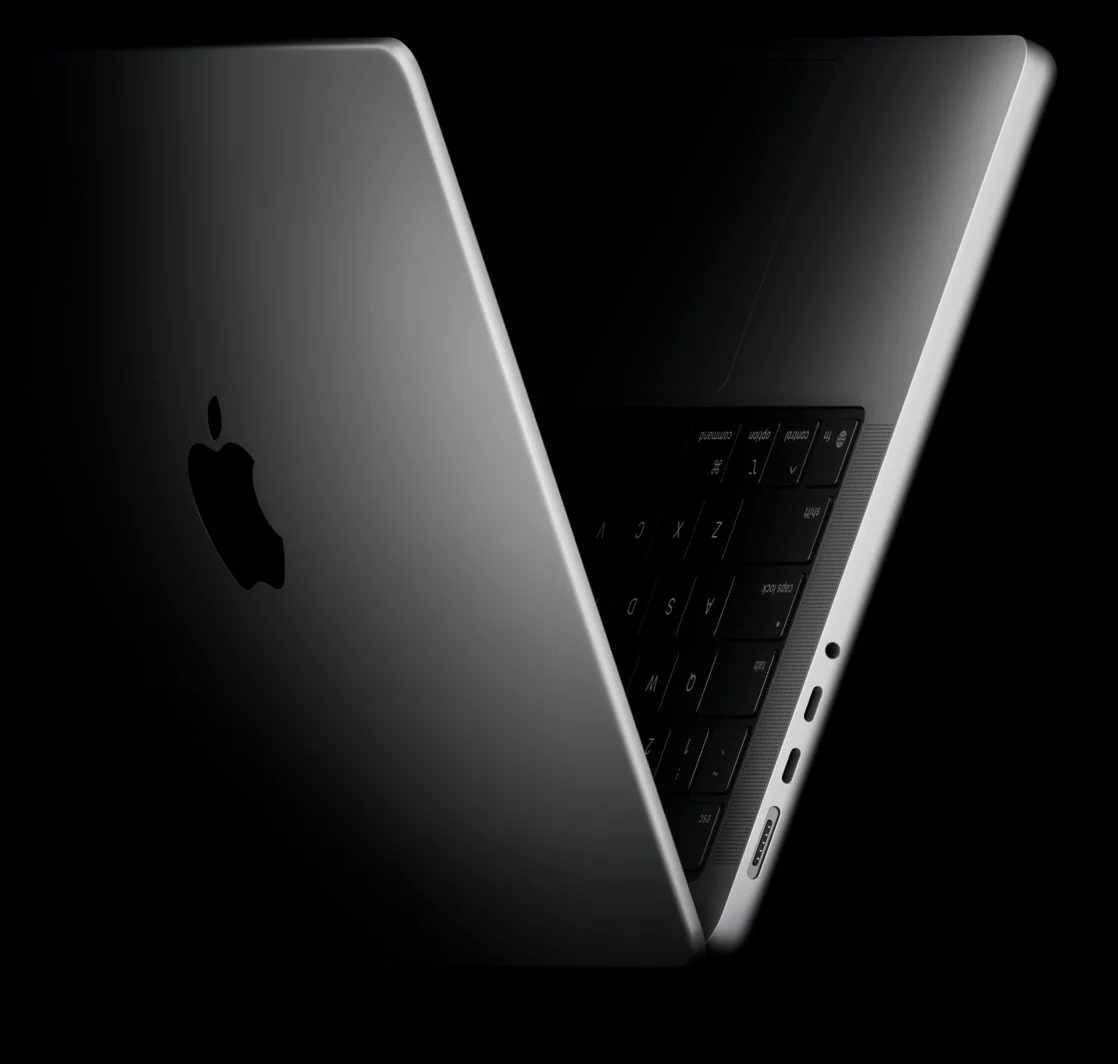 MacBook prateado entreaberto, iluminado de lado